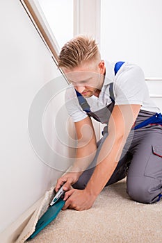 Person Cutting Carpet With Cutter