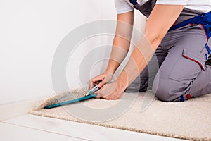 Person Cutting Carpet With Cutter