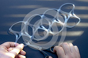 A person cutting a eight pack rings or eight pack yokes with scissors