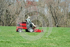 Person cutting the lawn on a riding mower