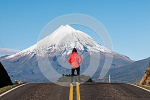 Person deep thinking in front of mountain peak.
