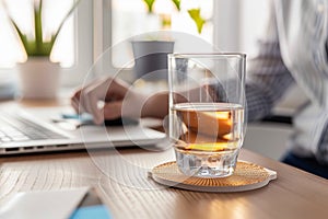 person at a desk, coaster with halfempty glass of water