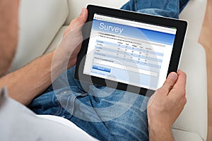 Person With Digital Tablet Showing Survey Form photo