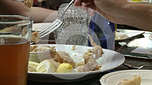 A person dipping fried food into Tarter Sauce