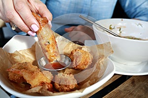 Person dipping Vietnamese Shrimp Spring Roll into sauce