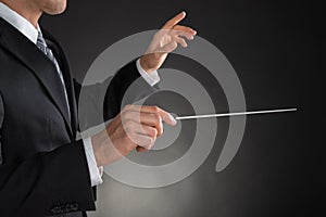 Person Directing With A Conductor`s Baton photo