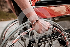 Person with disability sitting in the wheelchair and putting hand on the wheel