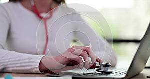 Person doctor puts stethoscope on laptop keyboard