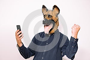 Person with a dog mask winning with the phone