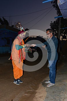 The person donates rice and money to the beggar before dawn in Sijohora Madhya Pradesh India.