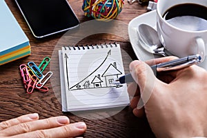 Person Drawing House Prices Growth Concept On Notepad