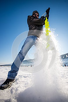 Person drilling ice in the winter