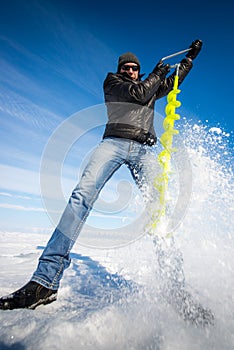 Person drilling ice in the winter