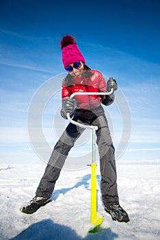 Person drilling ice in the winter