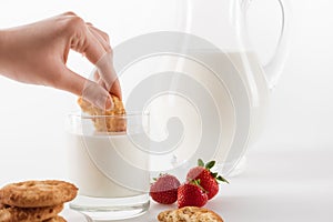 Person eating cookies with fresh milk and strawberries