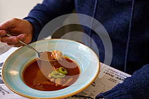 A person eating Hungarian fish soup with catfish