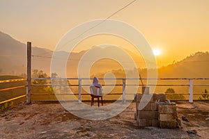 Person enjoying the sunrise view of forest and mountains, summer landscape with foggy hills at sunrise