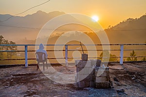 Person enjoying the sunrise view of forest and mountains, summer landscape with foggy hills at sunrise