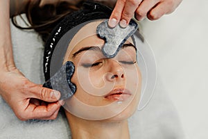 Relaxing facial treatment at a spa with gua sha tools during an afternoon session photo