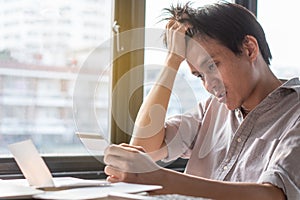 Person exhausted with bankruptcy problem. shocked man carrying bills and credit card on his hands worry about bank notification