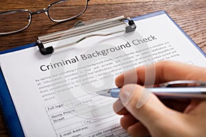 Person Filling Criminal Background Check Application Form