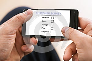 Person filling customer survey form on mobile phone