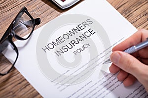 Person Filling Homeowners Insurance Policy Form