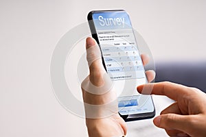 Person Filling Online Survey Form On Mobile Phone