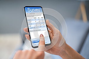 Person Filling Survey Form On Mobile Phone