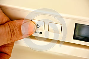 Person finger pressing an on off button
