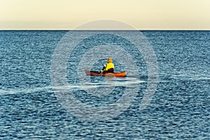 Person fishing in a canoe in a blue sea in Hawaii, United States.