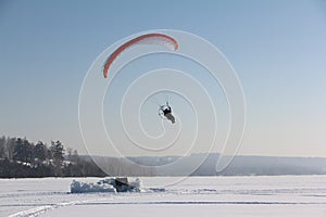 The person flying on a motorized paraplane against the snow