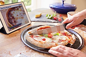 Person Following Pizza Recipe Using App On Digital Tablet