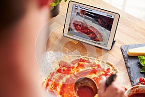 Person Following Pizza Recipe Using App On Digital Tablet