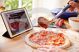 Person Following Pizza Recipe Using App On Digital Tablet