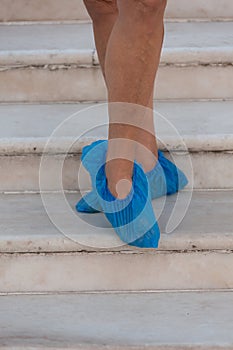 A person with foot coverings on the steps of a temple in Asia.