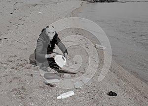 Person in gas mask collects garEclogy, pollution, garbage dumps near the city, lots of plastic bottles and celophane bags, rubbish