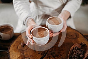 Person giving ceremonial cacao in cup. chocolate drink top view