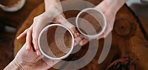 Person giving ceremonial cacao in cup. chocolate drink top view