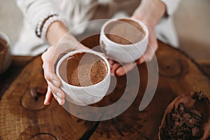 Person giving ceremonial cacao in cup. chocolate drink top view