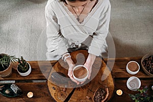 Person giving ceremonial cacao in cup. chocolate drink top view