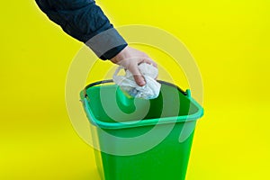 a person hand drop trash in the garbage bin