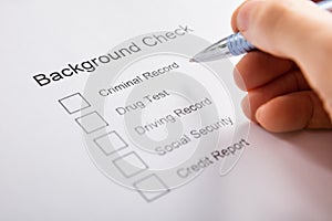 Person Hand Filling Background Check Form photo