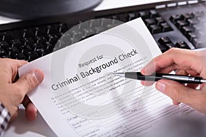 Person Hand Filling Criminal Background Check Application Form