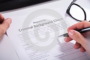 Person Hand Filling Criminal Background Check Application Form