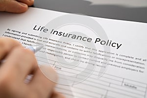 Person Hand Filling Life Insurance Policy Application