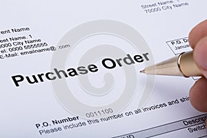 Person Hand Filling A Purchase Order Form photo