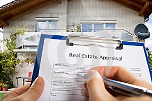 Person Hand Filling Real Estate Appraisal Document