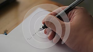 Person hand holding pen and writing on a book