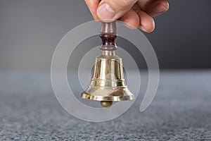 Person Hand Holding A Ring Bell